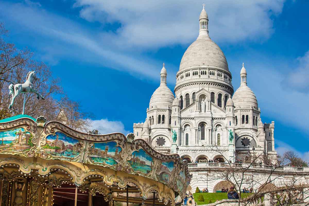 Carrousel and the Sacre Coeur Basilica at the Montmartre hill in Paris France.