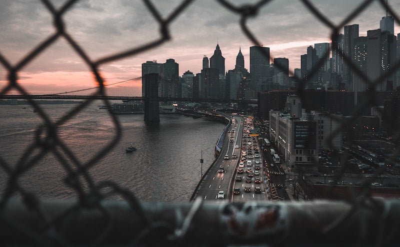 Holes in the fencing allow for better views from the Manhattan Bridge