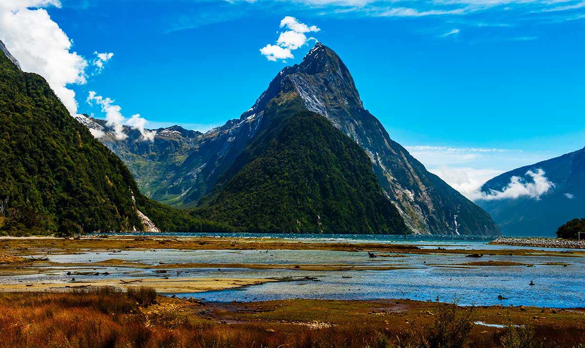 Famous Mitre Peak rising from the Milford Sound fiord at low tide. Fiordland national park, New Zealand.