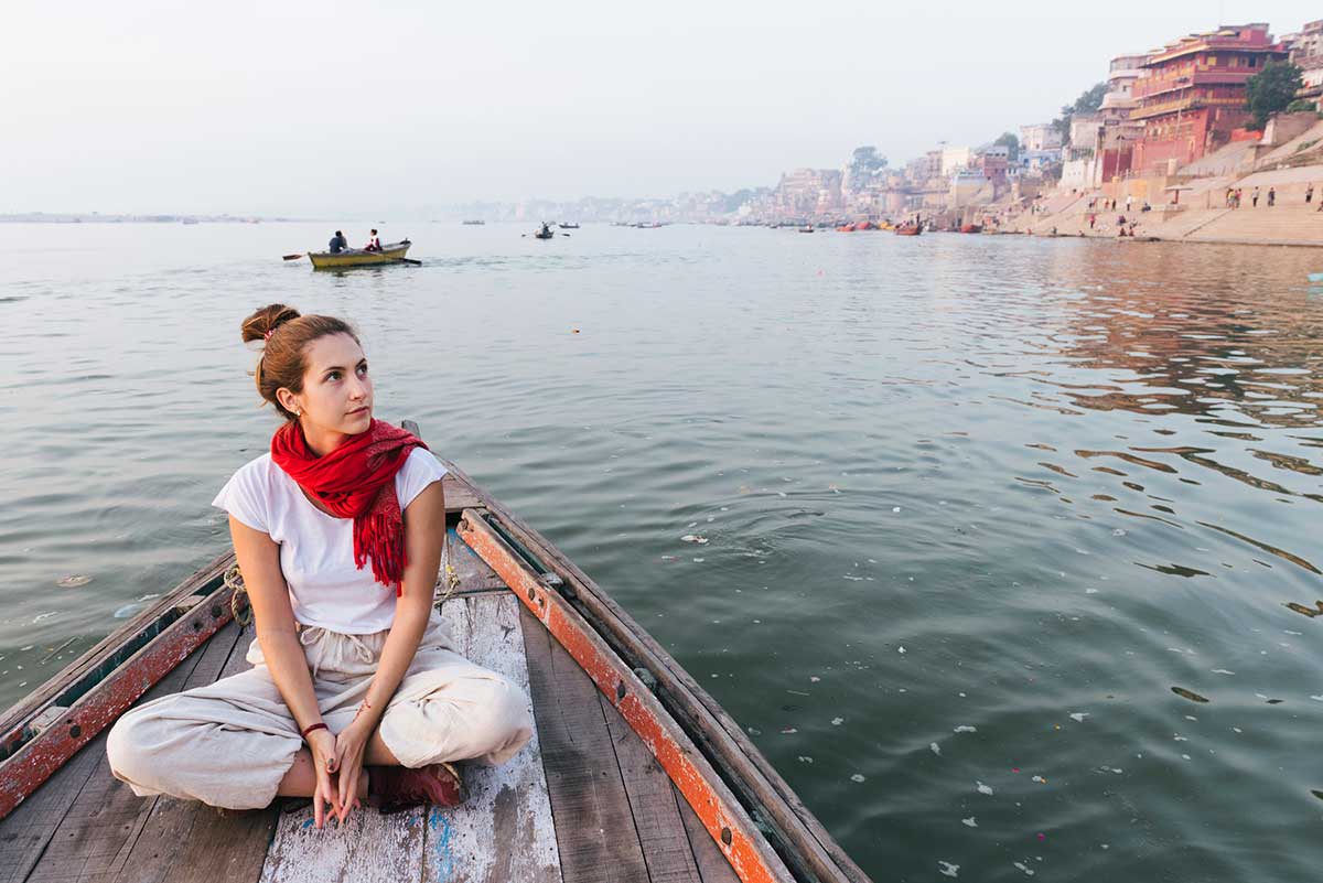 Western woman on a boat exploring the River Ganges.