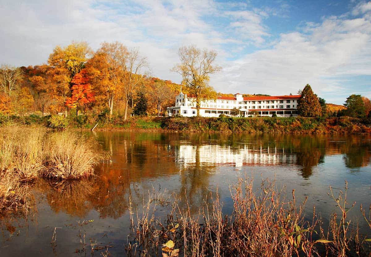 A view of a lake and The Shawnee Inn & Golf Resort in the fall.
