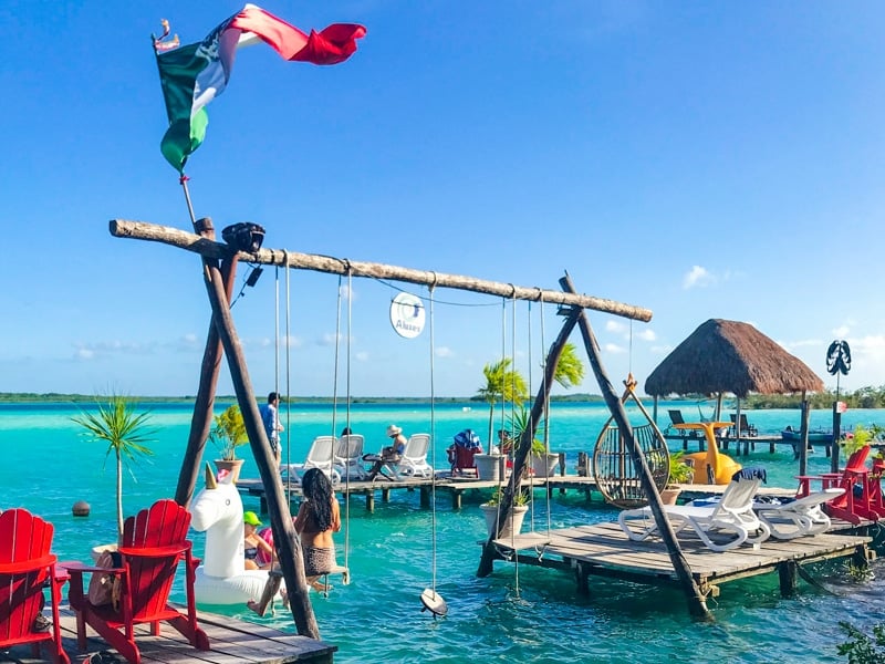 solo traveler in Mexico enjoying Bacalar's overwater swings