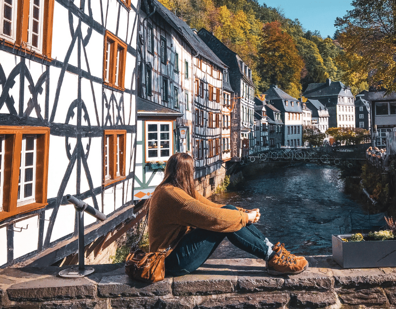 Woman sitting on the water in Germany and enjoying the digital nomad lifestyle