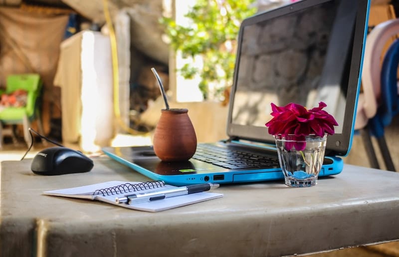 Digital nomad work essentials including a laptop and notebook