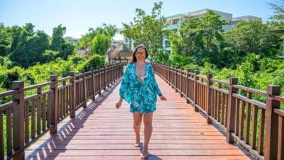 solo female traveler walking alone through palm trees in Mexico