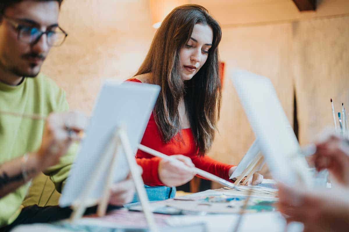A group of friends engaged in creative artwork at a painting class in NYC.