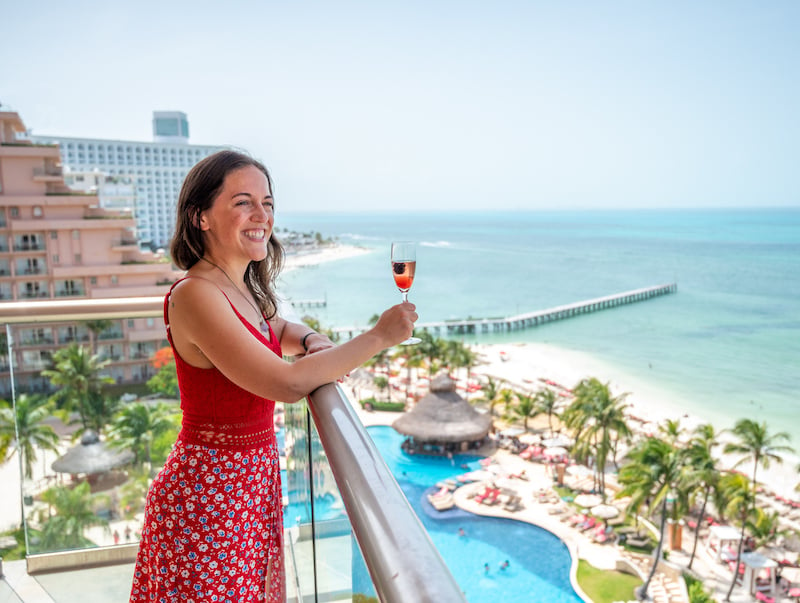 woman on her master suite balcony at the Grand Fiesta Americana Coral Beach Cancun All-Inclusive Resort