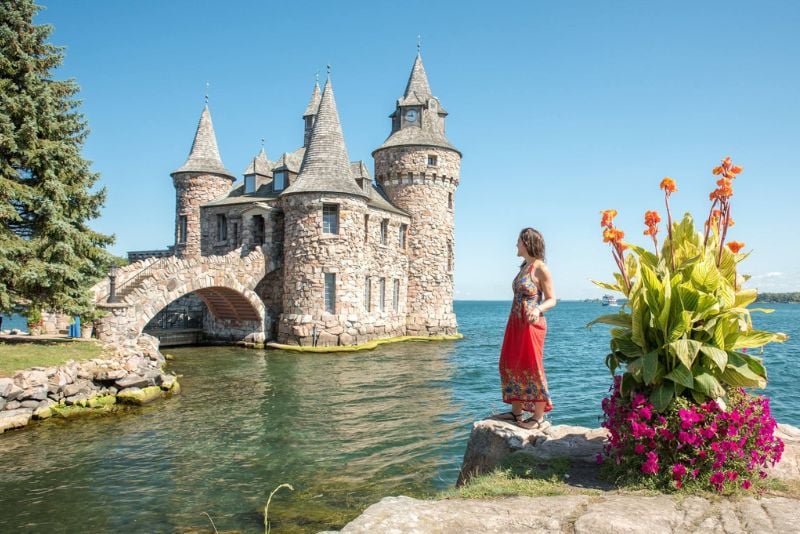woman posing in front of Boldt Castle in the 1000 Islands during a road trip from NYC