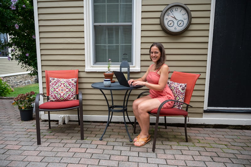 female travel blogger working on her laptop at an Airbnb