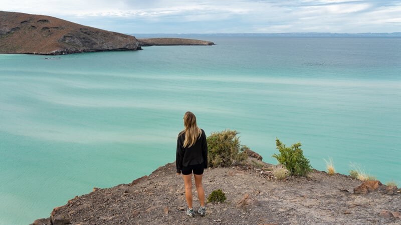 woman gazing out over Balandra Bay from the circuit hiking trail in Baja California Sur