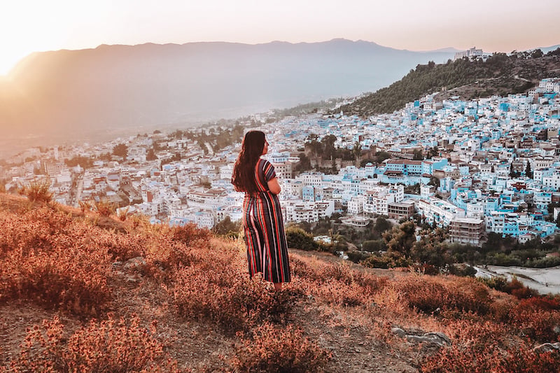 woman looking out over Chefchaouen, Morocco while traveling solo in the Middle East