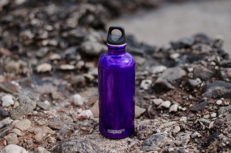 purple water bottle in rocks