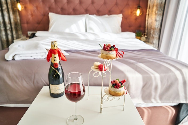 Champagne and pastries next to a hotel bed
