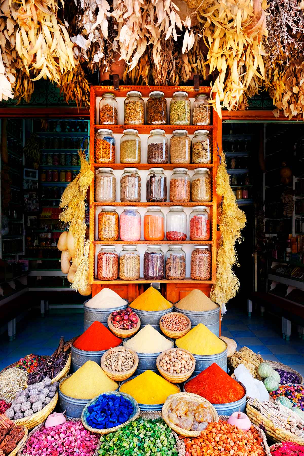 solo female traveler in Morocco perusing colorful bags of spices in Marrakech