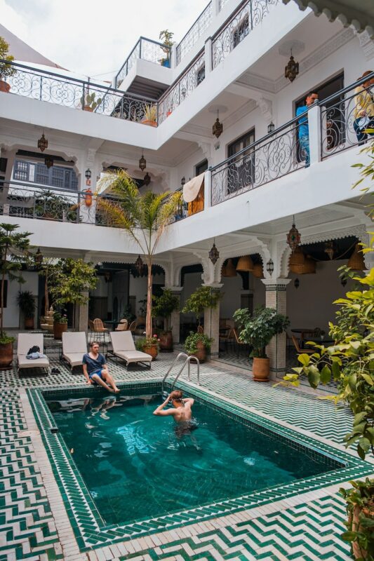 solo travelers in Morocco hanging out in the pool of a traditional riad accommodation