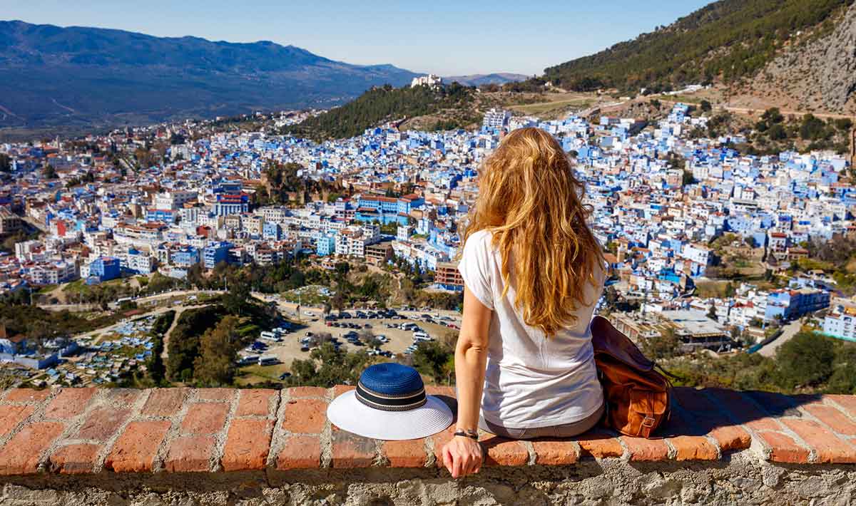 Solo female traveler in Morocco looking out over the blue buildings of Chefchaouen.
