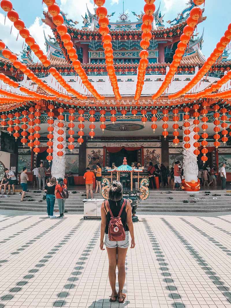 Woman standing in front of a temple in Malaysia.