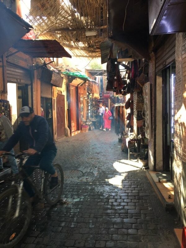 people shopping in a very narrow Marrakech souk