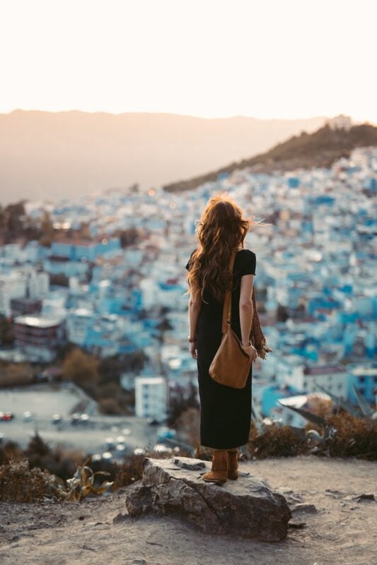 solo female traveler in Morocco looking out over the blue buildings of Chefchaouen