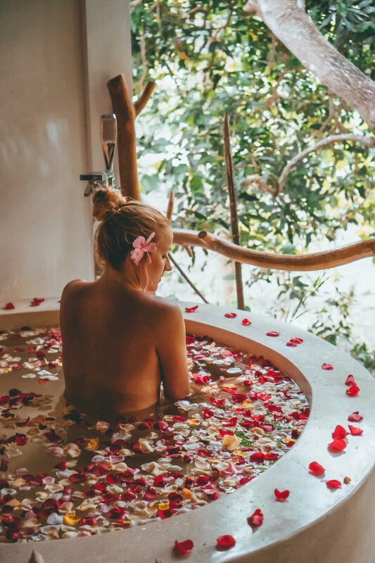 woman relaxing in the best flower bath in Bali at La Cabane