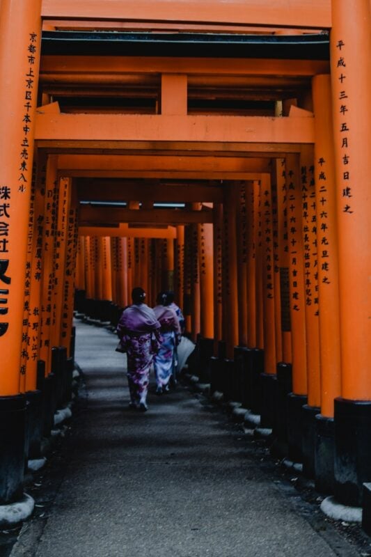 women walking through the Fushimi Inari Shrine in Kyoto, Japan