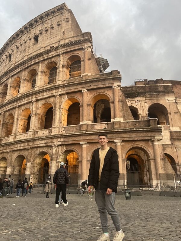 traveler standing in front of the Colosseum in Rome