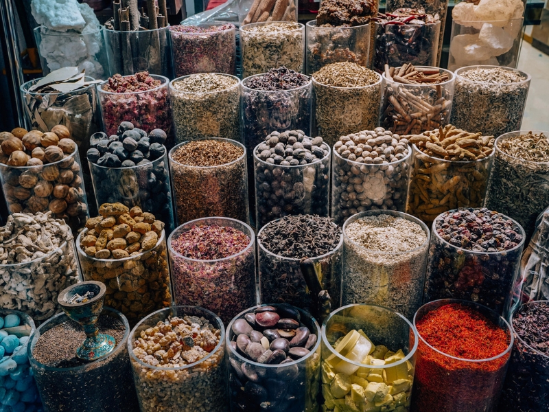 solo traveler in Dubai buying colorful spices at a souk 
