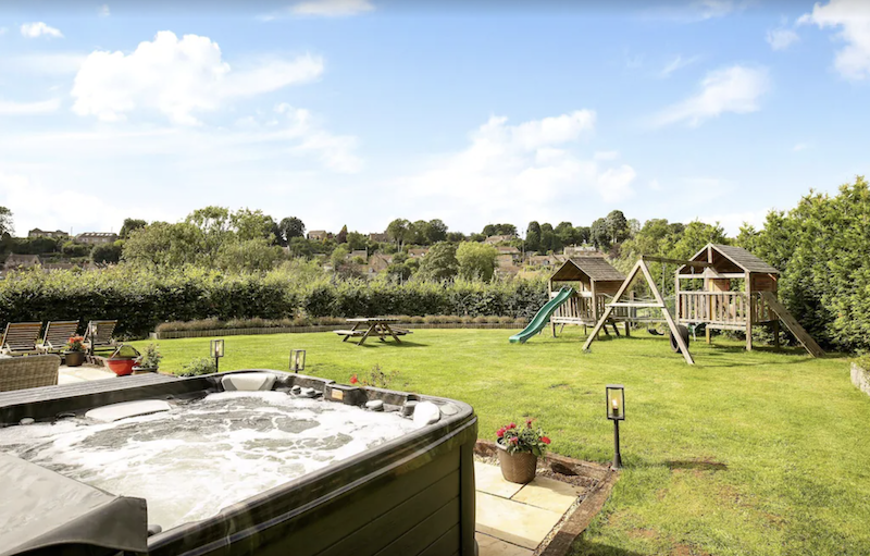 backyard with hot tub and swing set in the Cotswolds, England