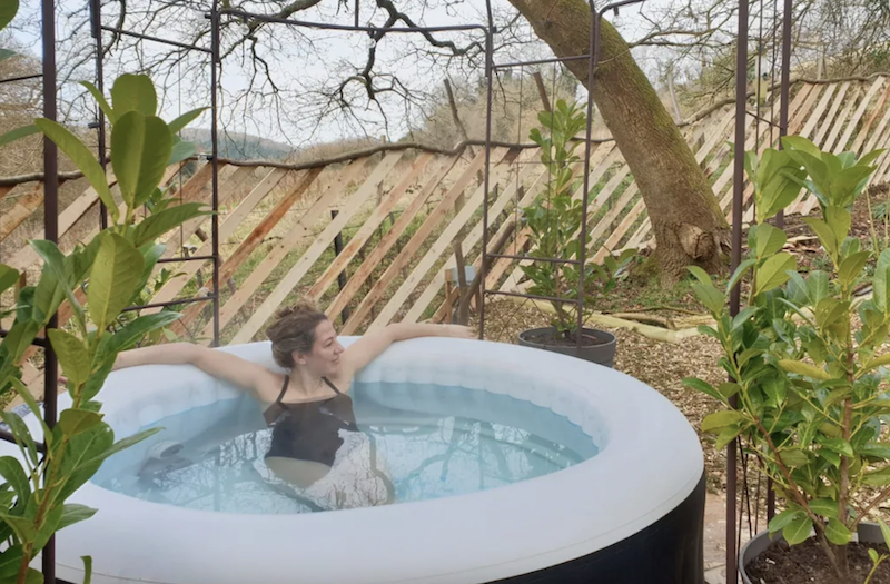 woman relaxing in a private hot tub at Cotswolds Way Cottage