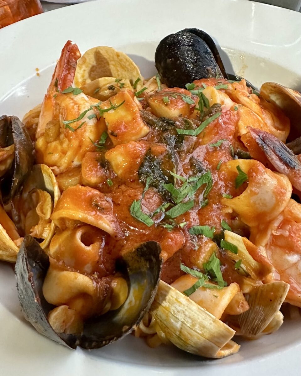 white bowl filled with seafood pasta in red sauce at Nick's Pizza in the Upper East Side