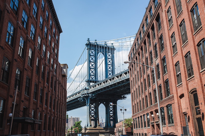 Manhattan Bridge flanked by brick buildings in DUMBO, Brooklyn
