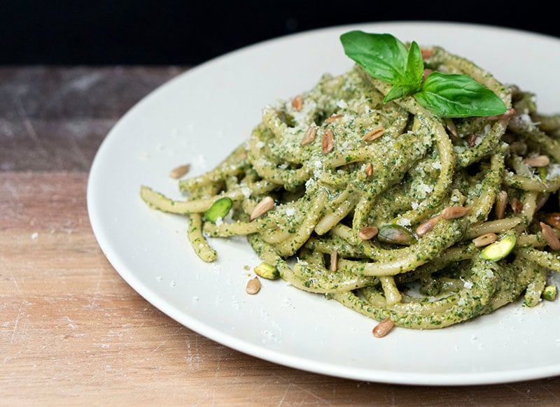 A close up photo of a dish of pasta with pesto.