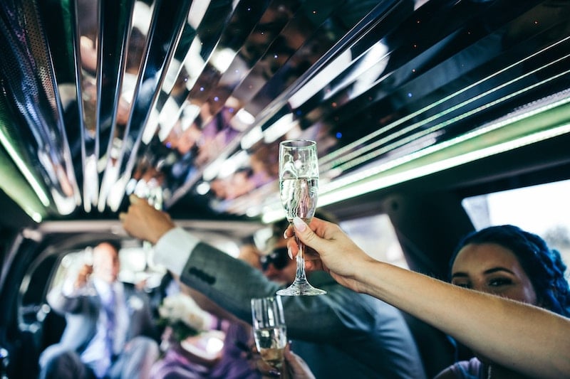 people clinking Champagne glasses on an NYC limo tour