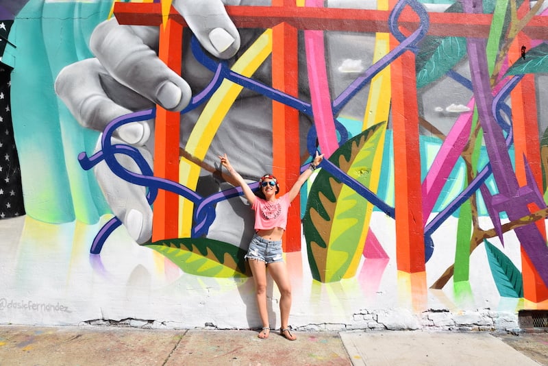 woman posing in front of a mural within the Bushwick Collective on a Brooklyn walking tour