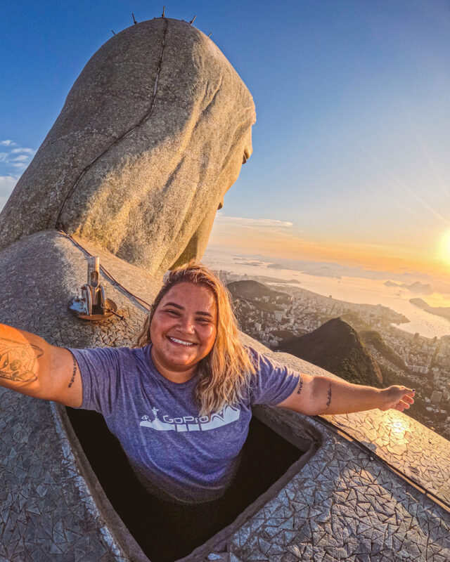 solo female traveler in Brazil climbing the Christ the Redeemer statue in Rio de Janeiro