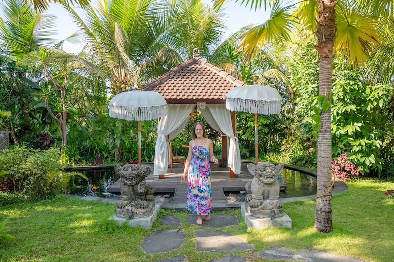 woman walking through lush palm trees at Adiwana Unagi Suites in Ubud