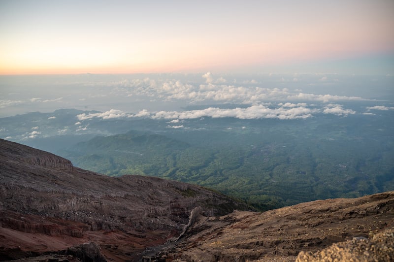 travelers standing above the clouds after hiking Mount Agung