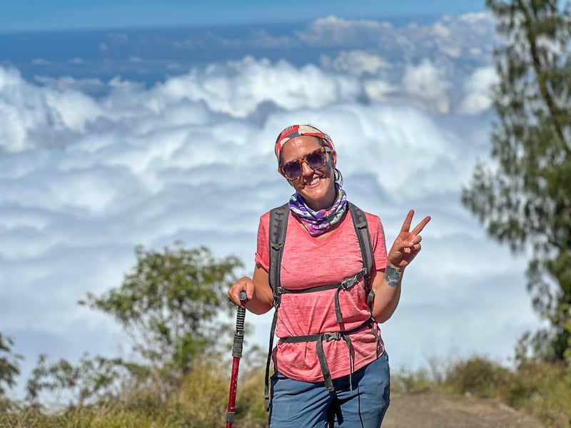 woman hiking up Mount Agung with clouds in the background
