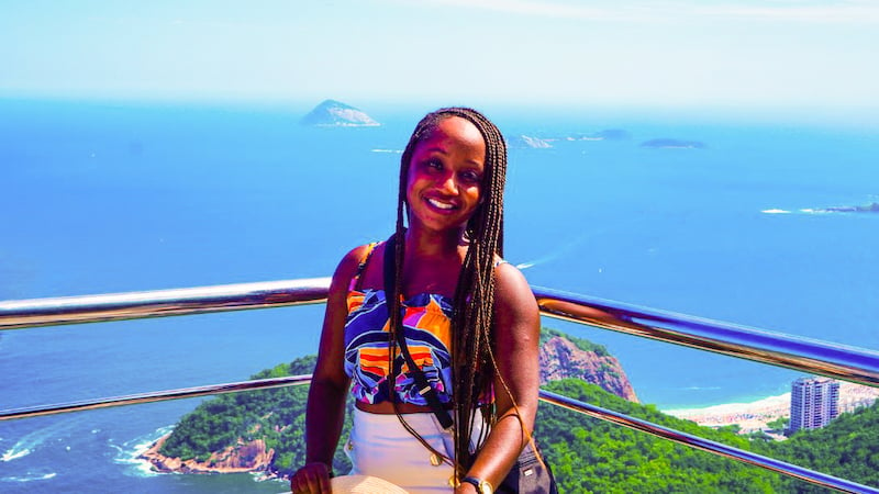 solo female traveler posing on top of Brazil's Sugarloaf Mountain