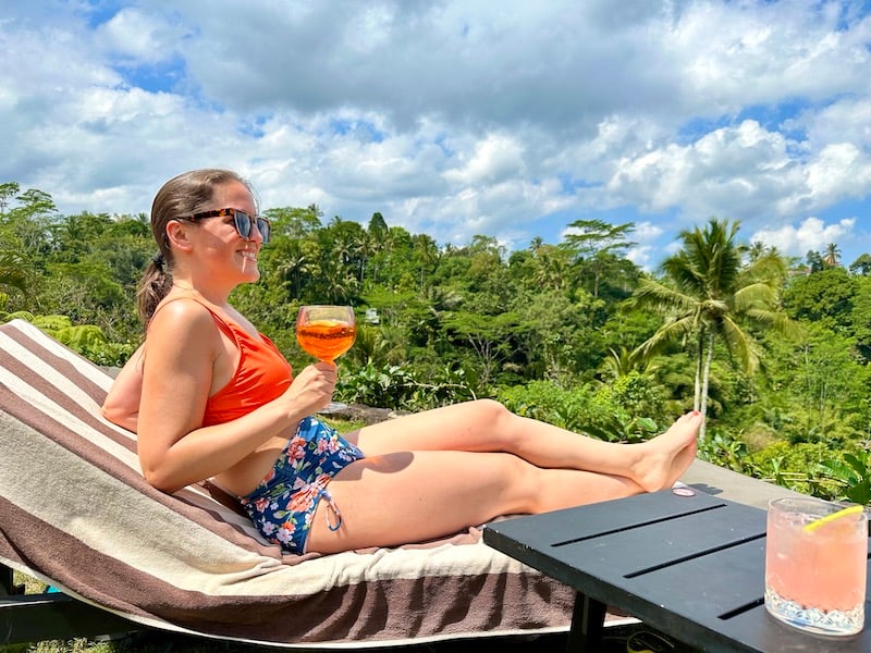 woman laying by the pool at Padma Resort Ubud at drinking a cocktail during a 2 week trip to Bali