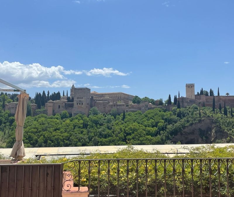 solo traveler in Spain gazing out over the Alhambra Palace in Granada