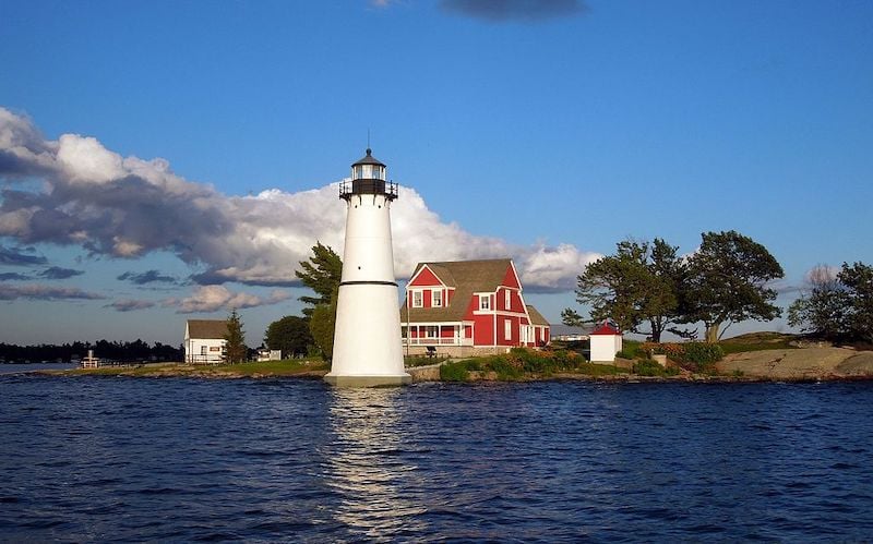 Rock Island Lighthouse in New York with a red house behind it 