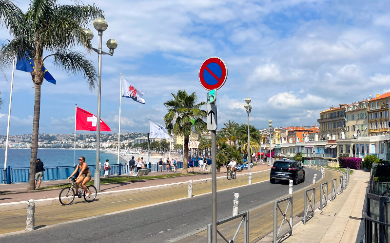 people walking along the waterfront of the Promenade des Anglais in Nice, France