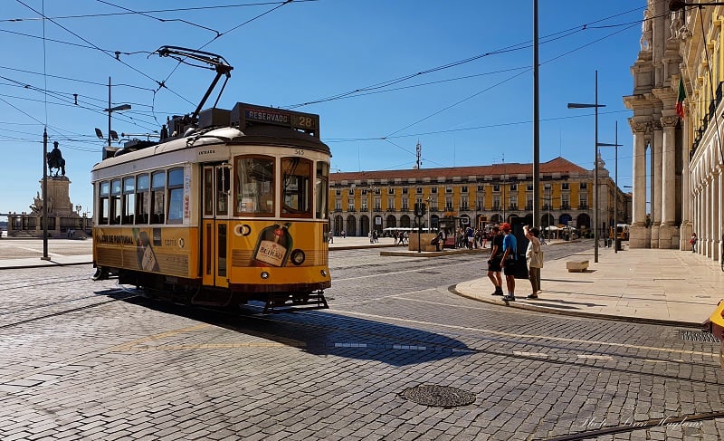person taking Tram no. 28 on Praça do Comércio during a solo trip to Lisbon