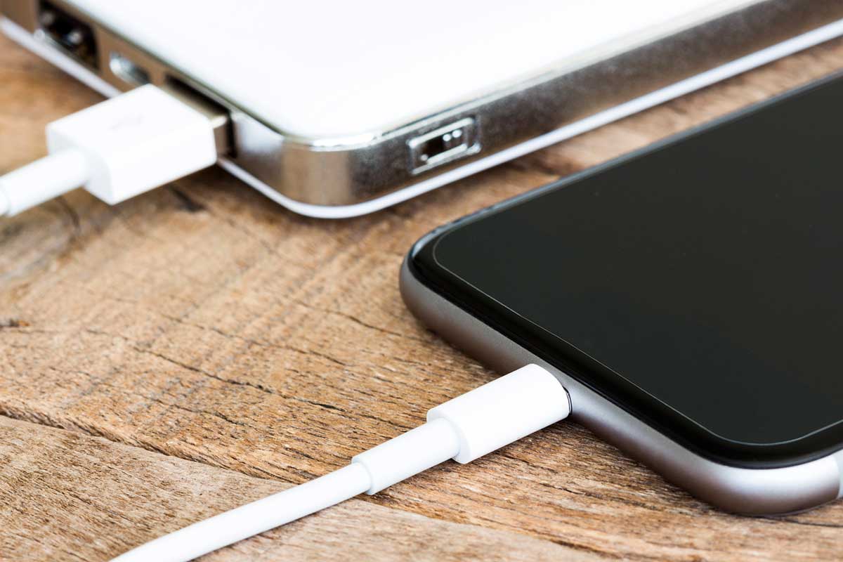 Closeup phone charging white power bank portable device.