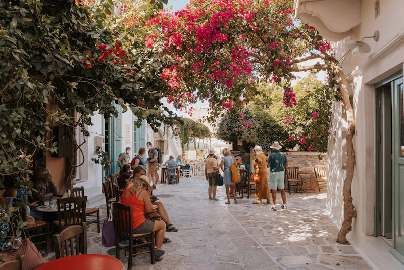 narrow streets flanked by white buildings and pink flowers in the Greek village of Village of Halki in Naxos