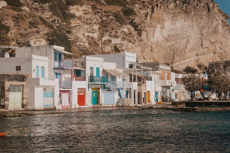 white buildings with bright color accents on the water in Klima on Milos
