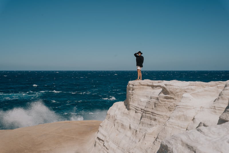 solo female traveler in Greece gazing out over Sarakiniko Beach in Milos