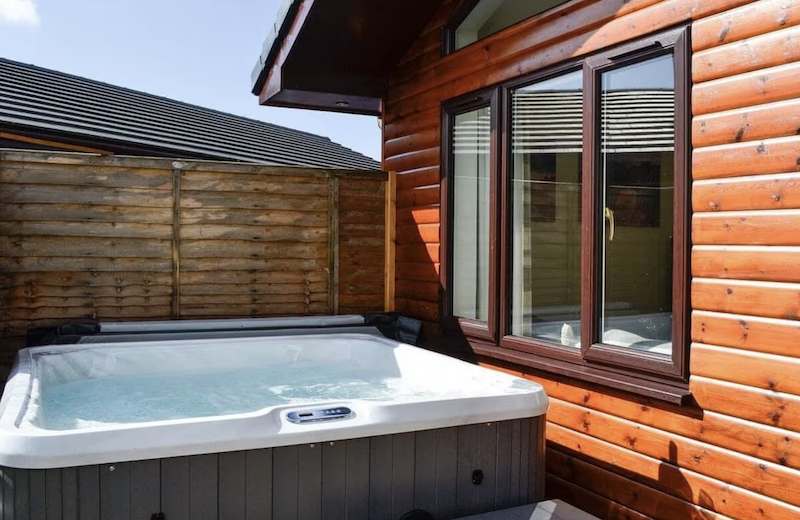 log cabin with a hot tub outside