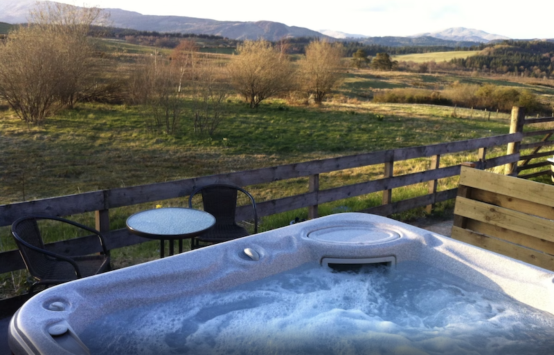 outdoor Jacuzzi overlooking the countryside at the Steading Farm Cottage Hot Tub lodge in Glasgow, Scotland